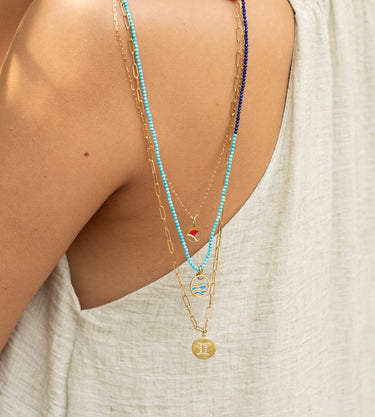 Golden Dusk enamel sunset pendant necklace worn on a fine gold chain