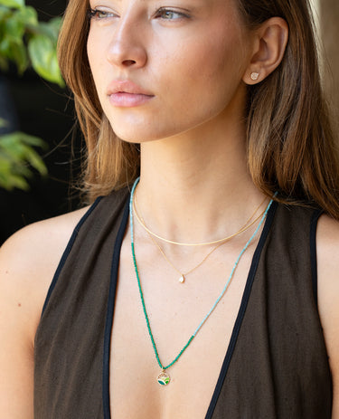 Valley Sunrise pendant worn close against the collarbone on a fine gold chain